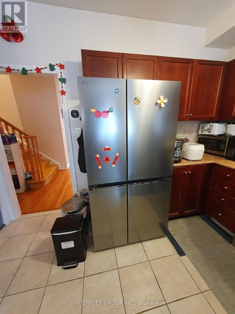 A stainless steel refrigerator with magnets and magnets on it in a kitchen.