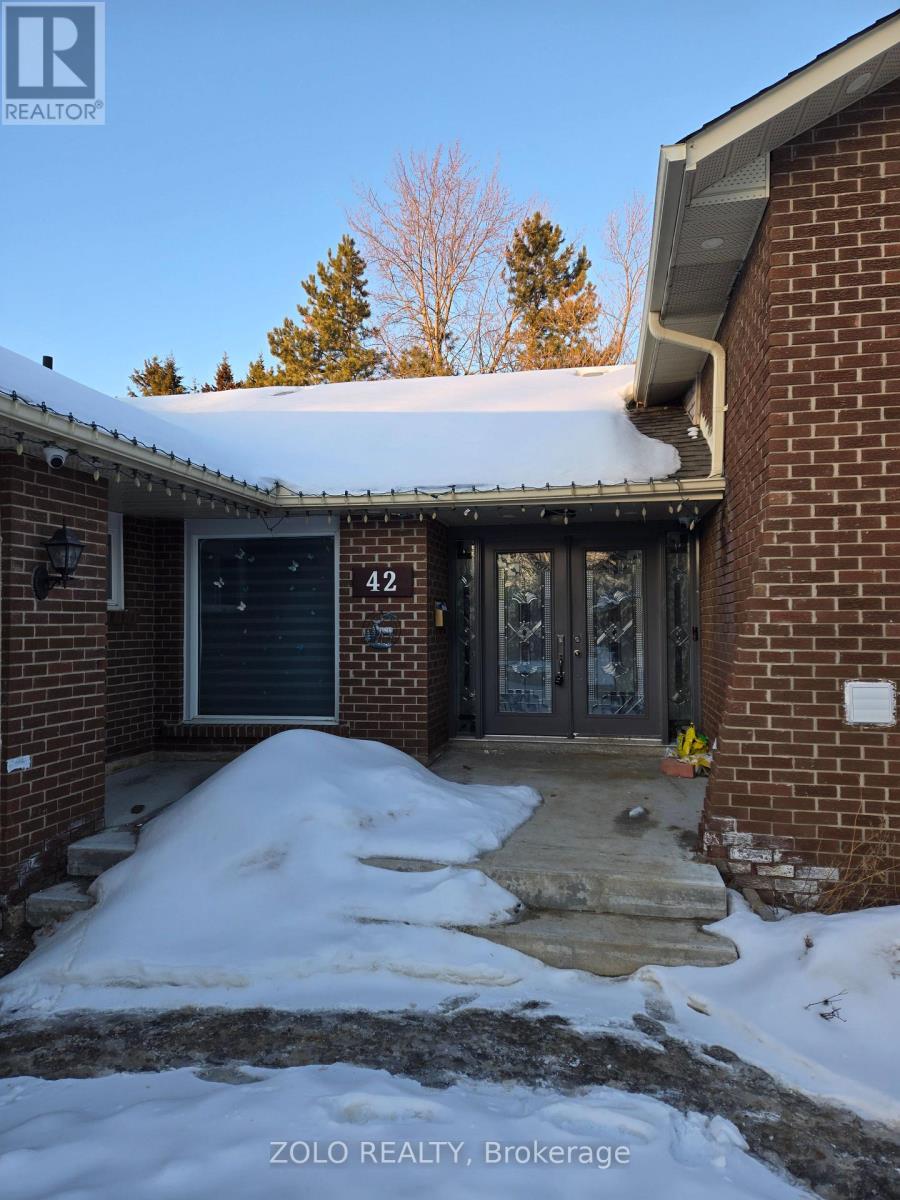A house entrance with snow on the ground and a sign that says Zolo Realty, Brokage.