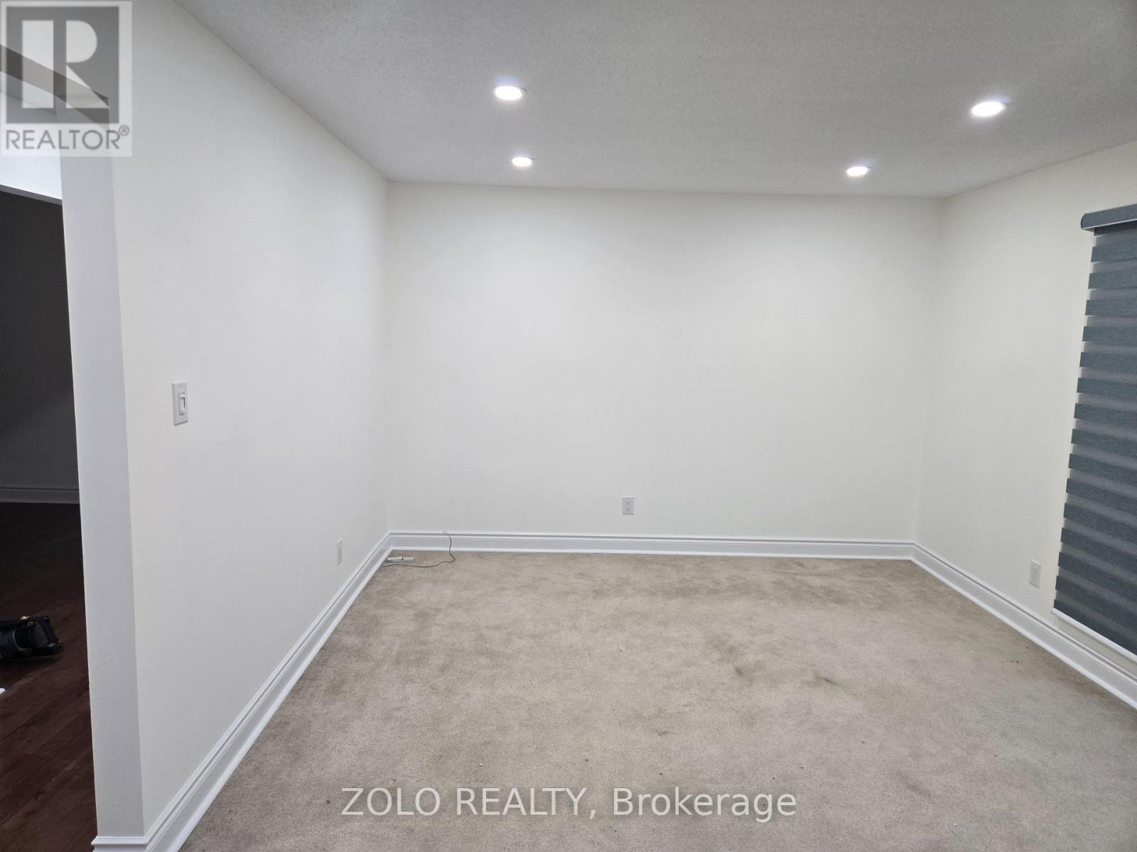 A room with white walls and carpeted floor.
