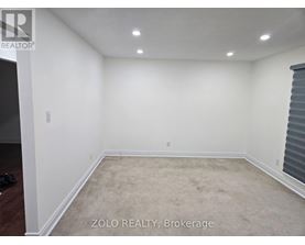 A room with white walls and carpeted floor.