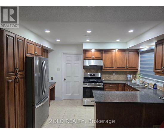 A kitchen with wooden cabinets and a stainless steel refrigerator.