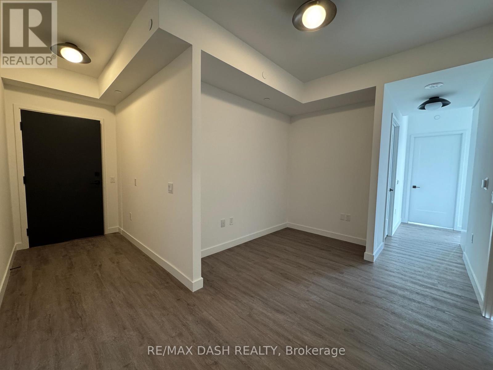 A room with a black door and a white door with a brokerage logo.