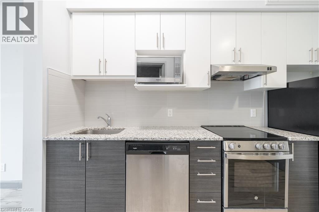 A modern kitchen with a stainless steel refrigerator and oven.