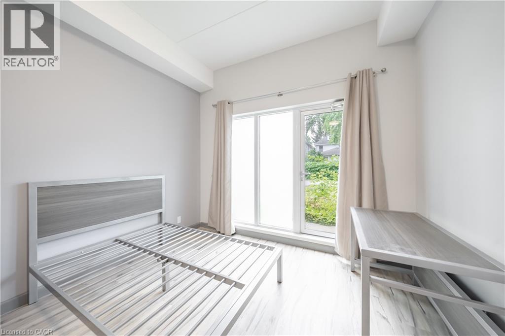 A bedroom with a bed, a bench, and a window.