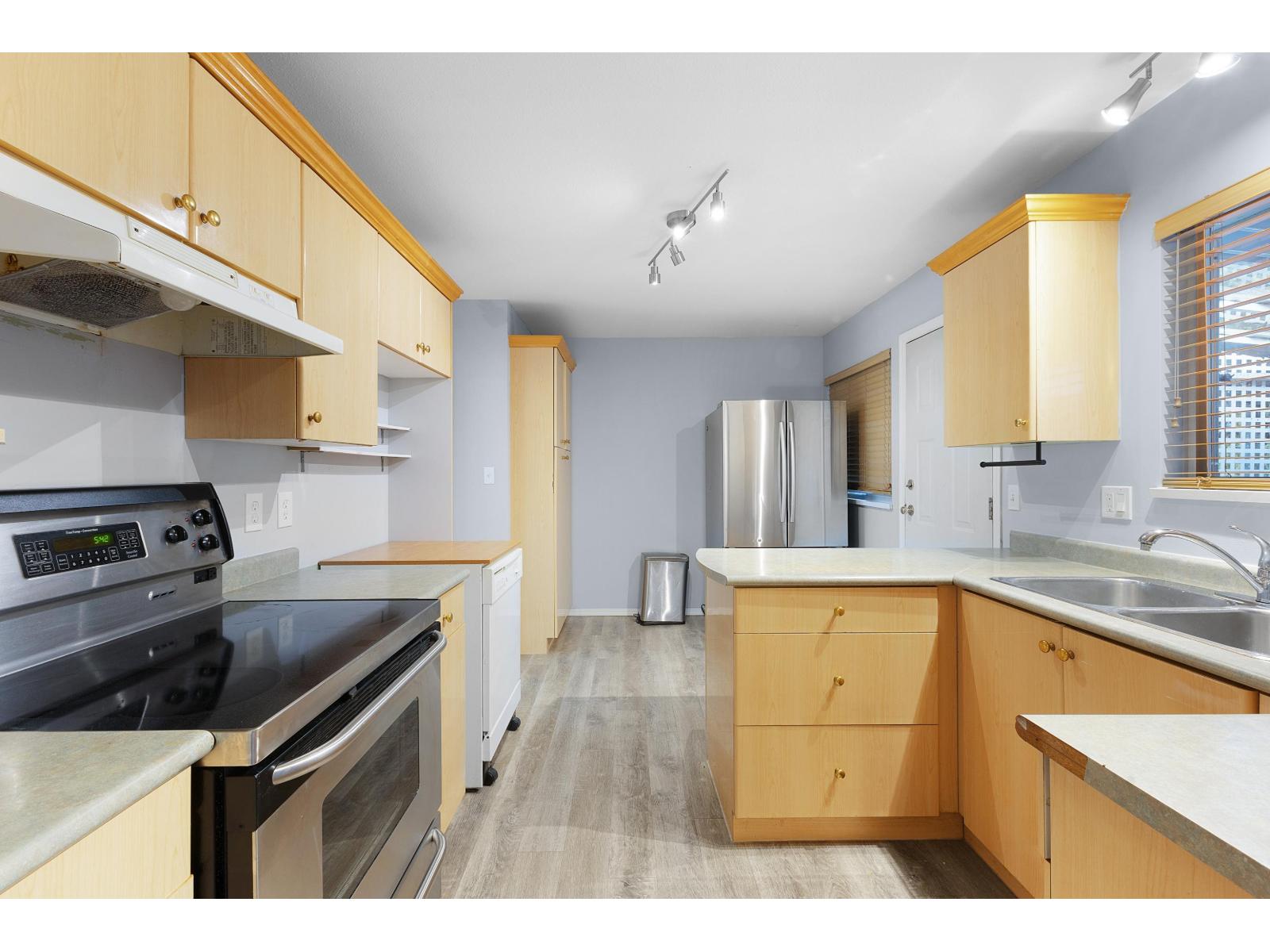 A kitchen with wooden cabinets and stainless steel appliances.