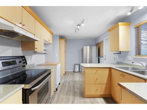 A kitchen with wooden cabinets and stainless steel appliances.