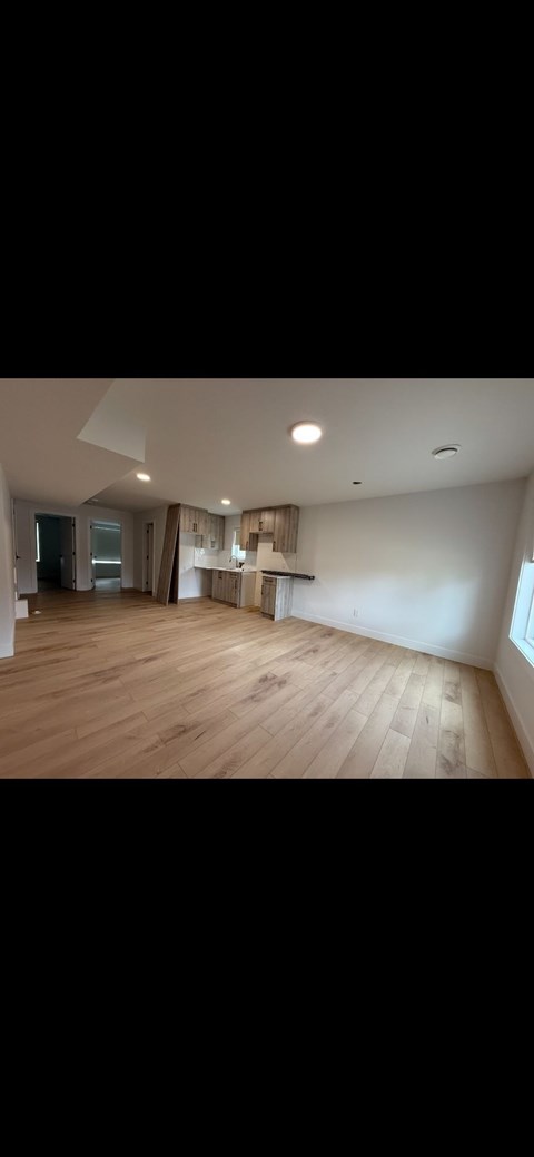 A room with wooden flooring and a window.