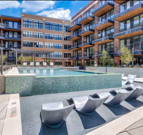 A modern building with a pool in front.