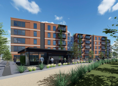 A modern apartment complex with a green space in front.