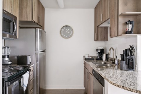A kitchen with a clock on the wall.