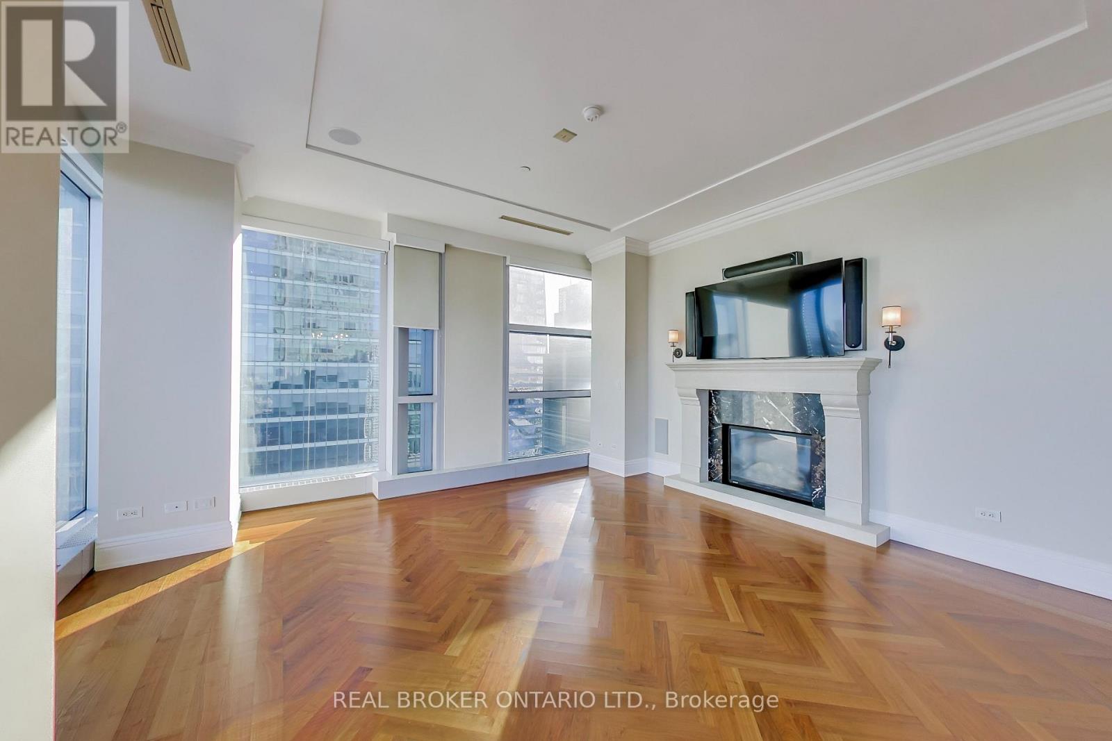 A spacious living room with wood flooring and a fireplace.