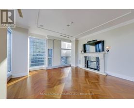 A spacious living room with wood flooring and a fireplace.