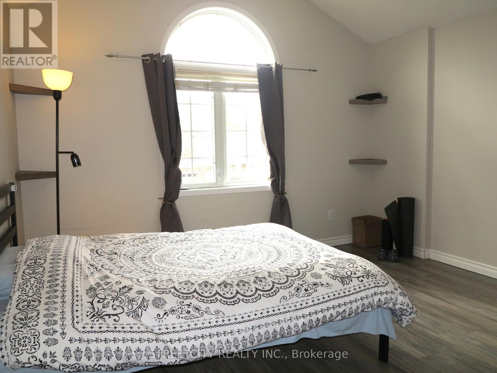 A bedroom with a bed covered in a patterned bedspread.
