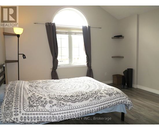 A bedroom with a bed covered in a patterned bedspread.