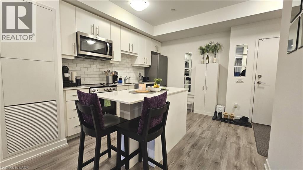 A kitchen with a table and chairs in front of it.