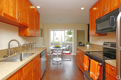 a kitchen with wooden cabinets and a table with chairs
