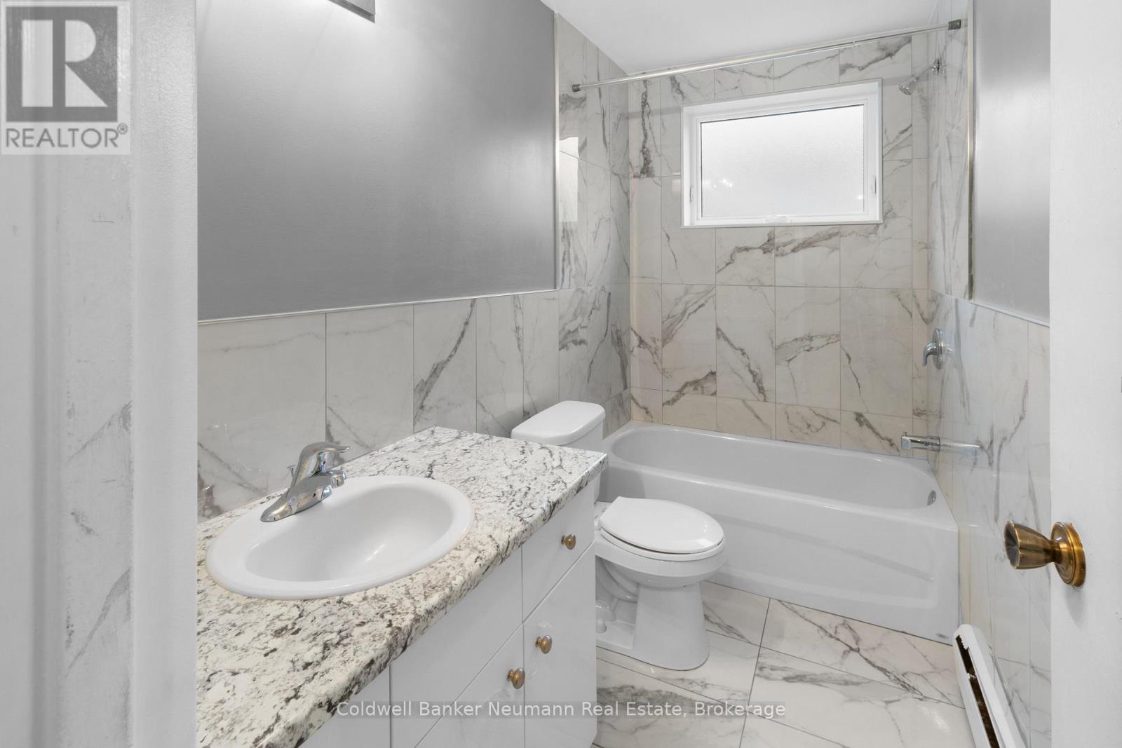 A bathroom with a marble countertop and a white toilet.