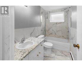 A bathroom with a marble countertop and a white toilet.