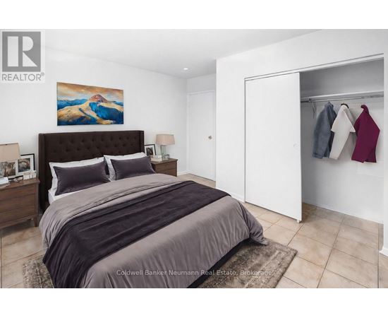A bedroom with a large bed and a painting on the wall.