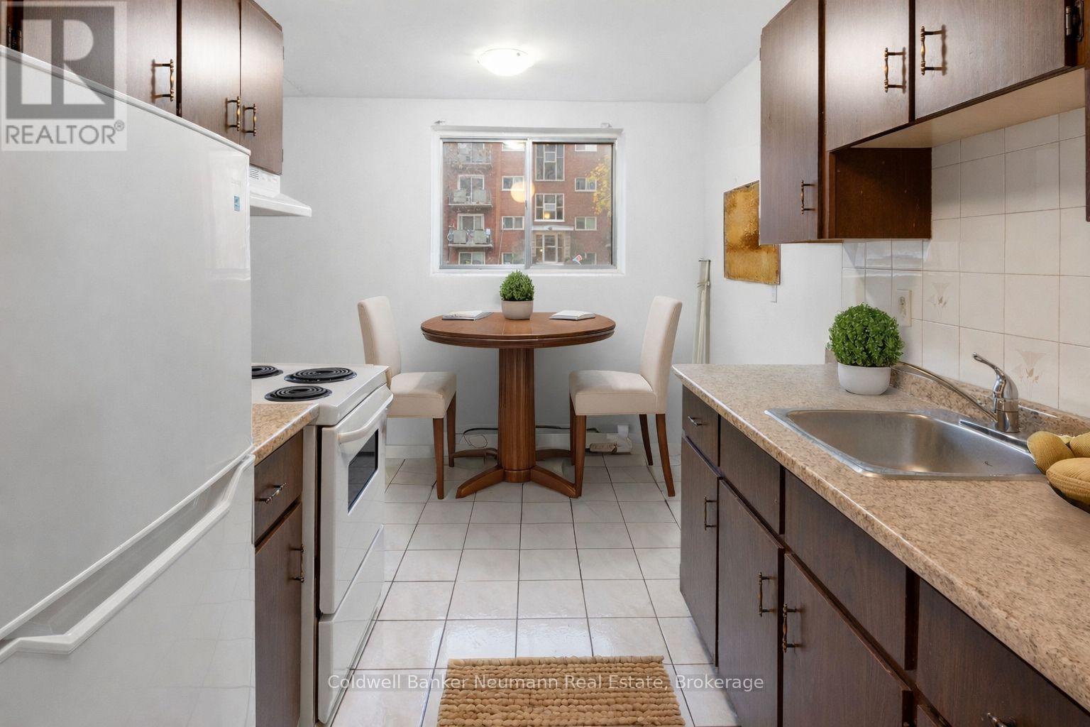 A kitchen with a table and chairs in the middle.