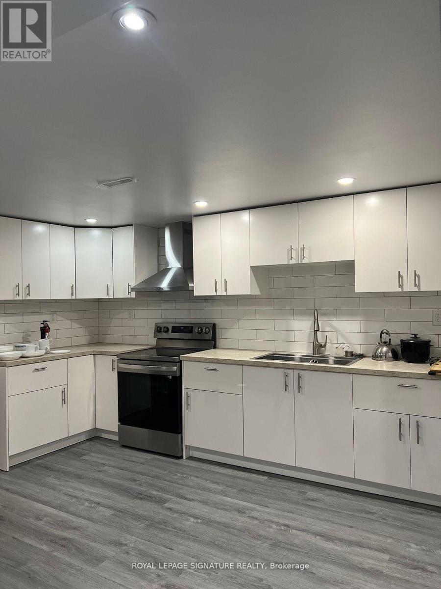 A modern kitchen with white cabinets and a stainless steel oven.