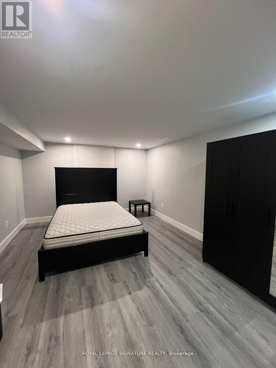 A bedroom with a bed, nightstand, and wardrobe.