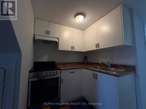 A kitchen with white cabinets and a black stove top oven.