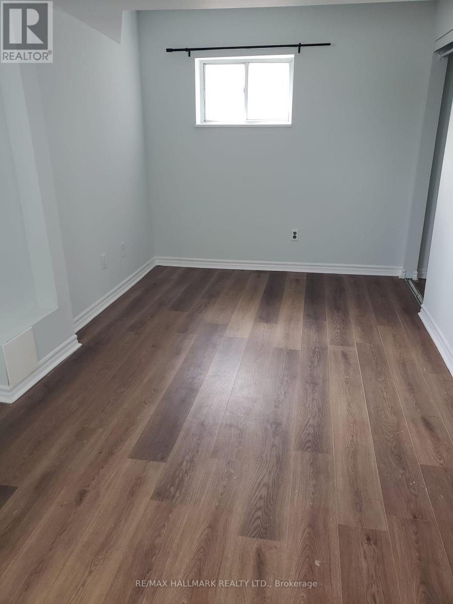 A room with wooden flooring and a window.