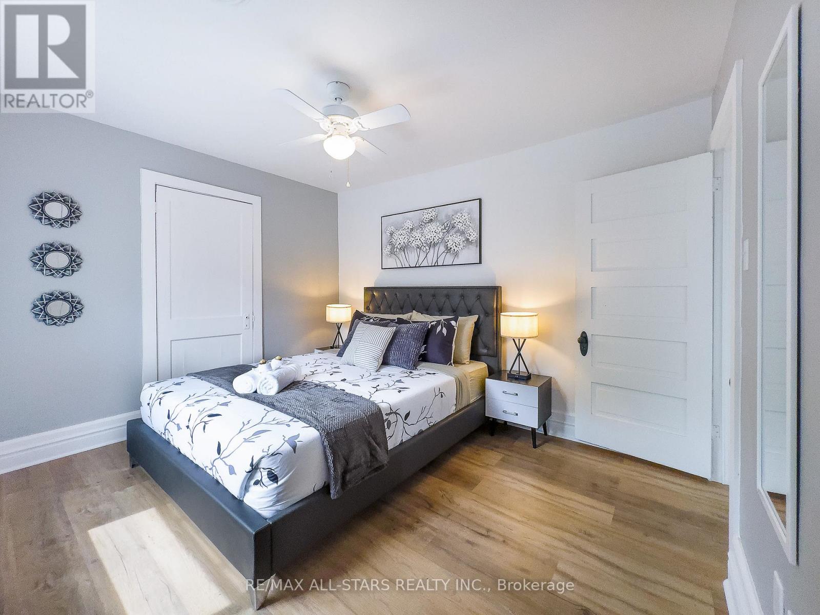 A bedroom with a large bed and a ceiling fan.