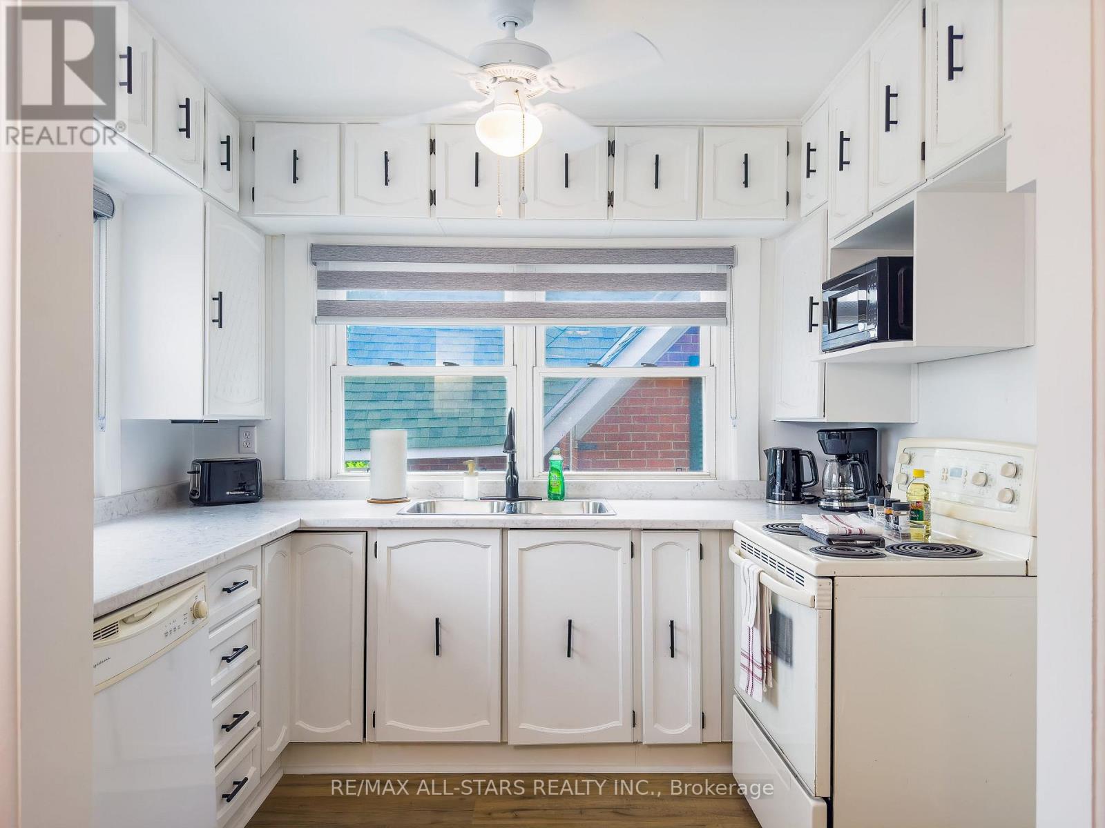 A white kitchen with a window and a sink.