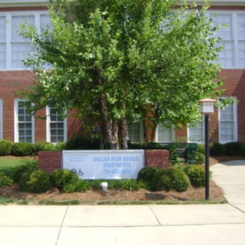 A sign in front of a building that says Dallas High School Apartments.