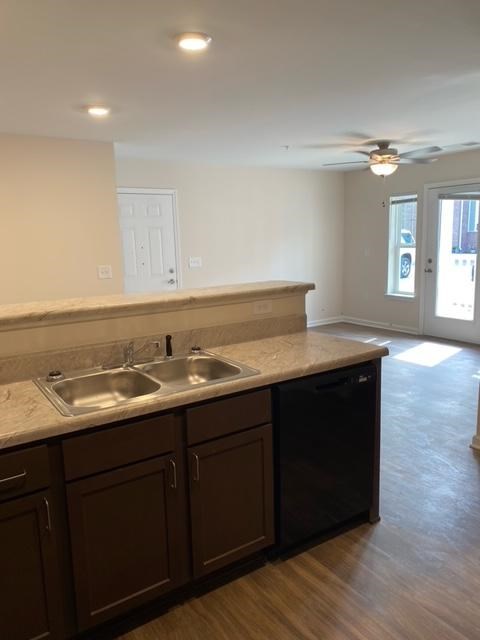 A kitchen with brown cabinets and a marble countertop.
