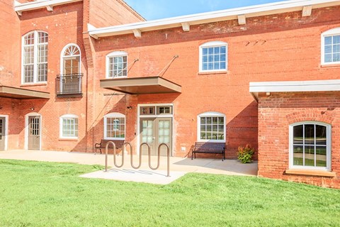 A red brick building with a green lawn in front.