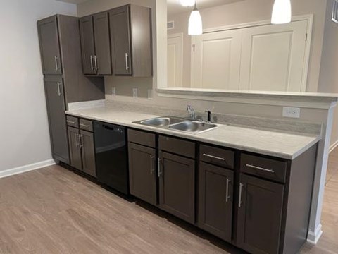 A kitchen with brown cabinets and a white counter.