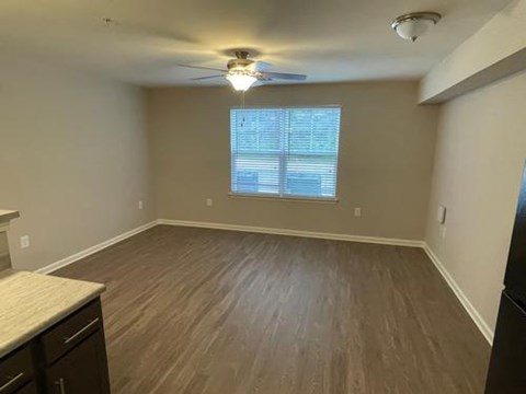 A room with a ceiling fan and a window with blinds.