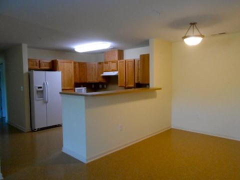 A kitchen area with a refrigerator and cabinets.