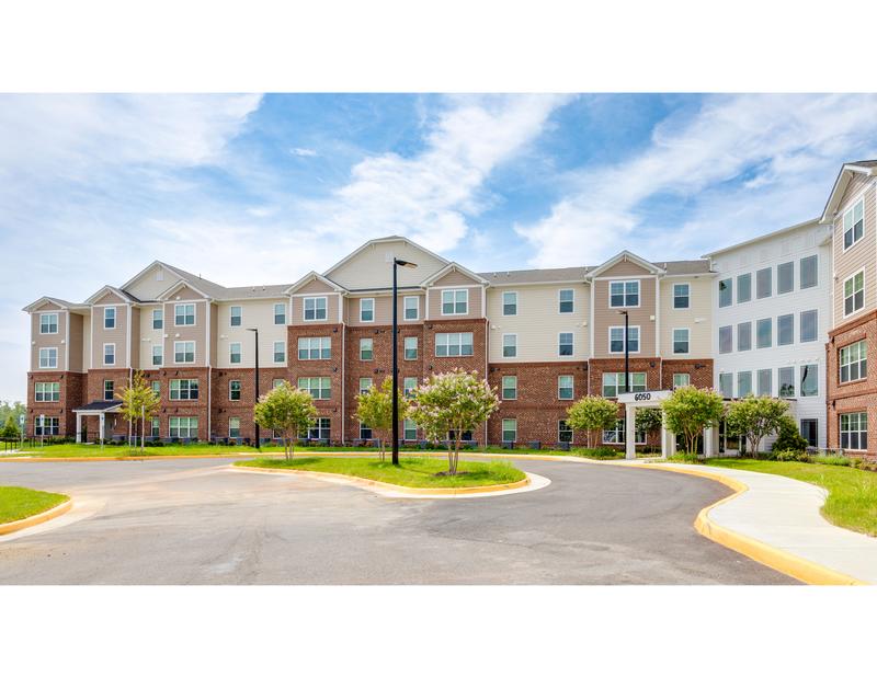 A large apartment complex with a roundabout in front.