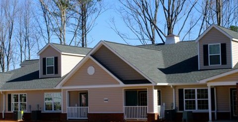 A house with a brown roof and a white fence.