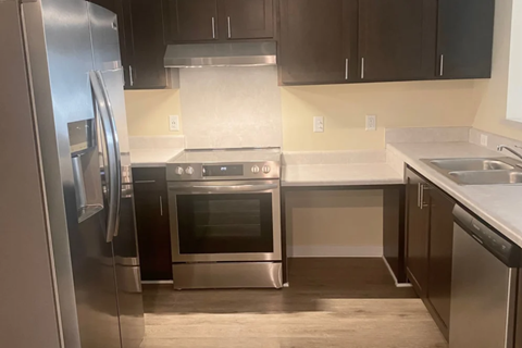 A modern kitchen with stainless steel appliances and a white countertop.