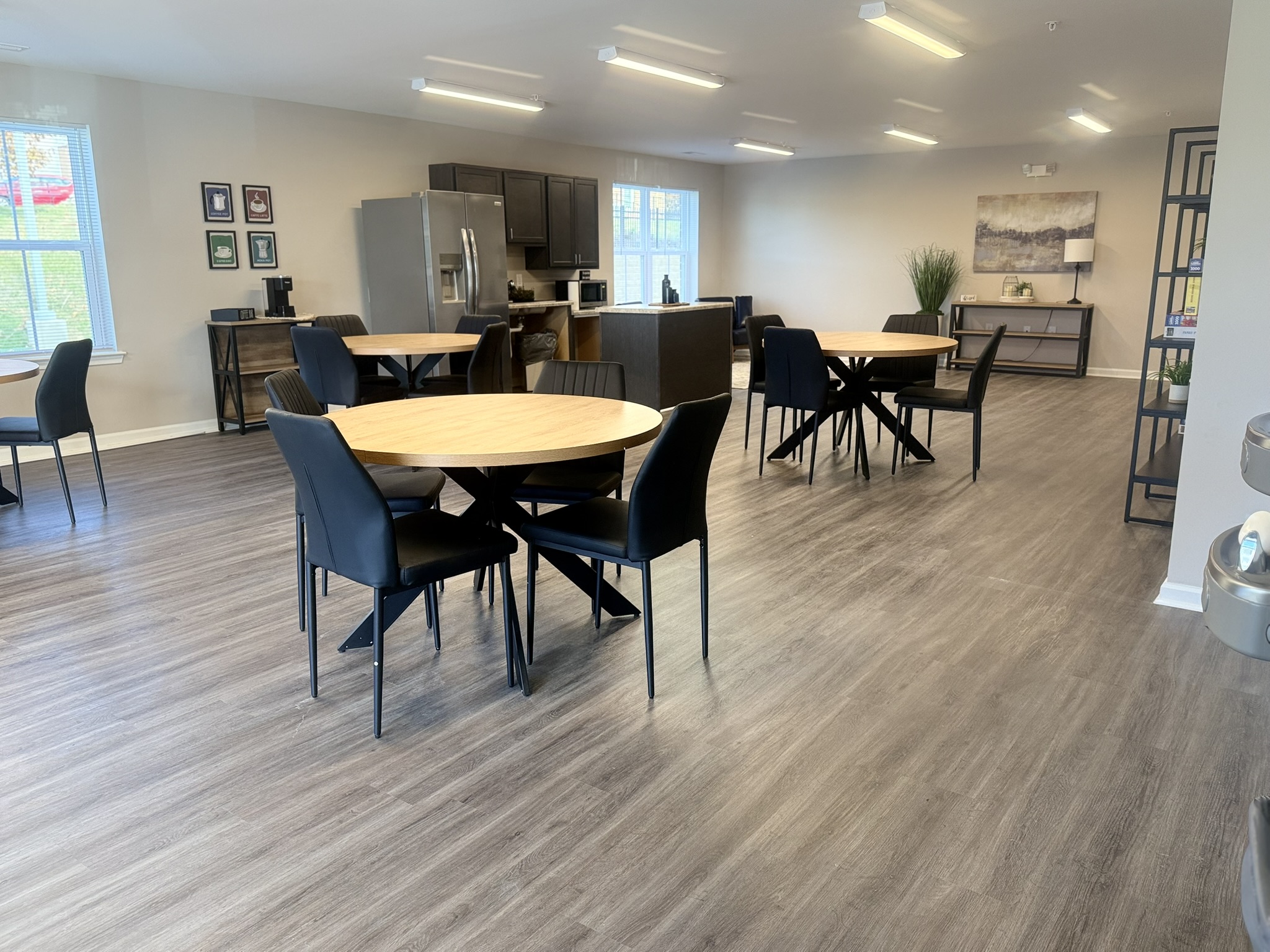 A dining room with a table surrounded by chairs.
