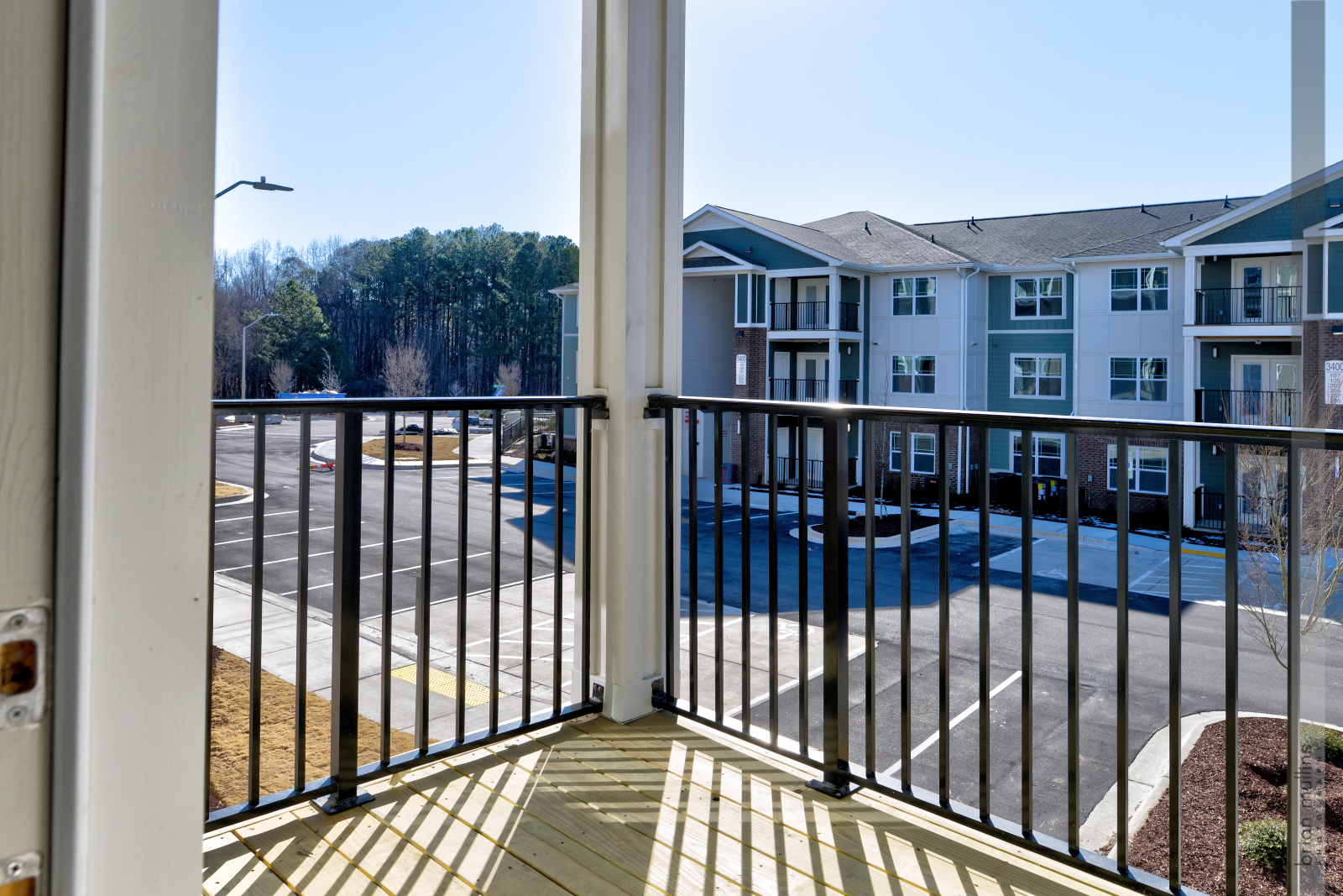A view from a doorway looking out to a pool and apartment building.