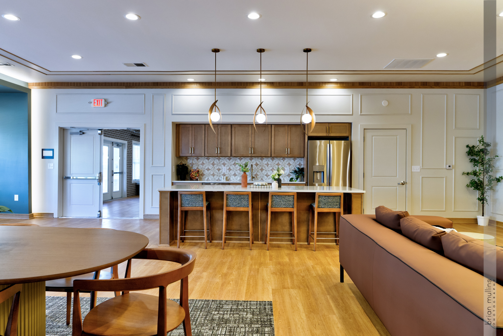 A modern living room with a wooden table and brown couch.