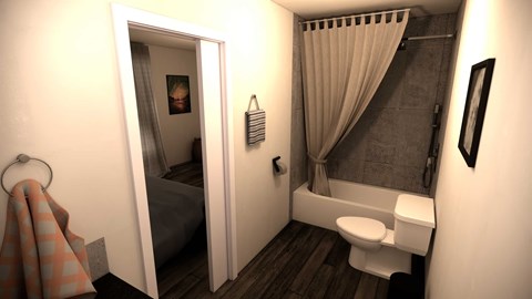 A bathroom with a toilet, a shower, and a bedroom with a bed and a picture.
