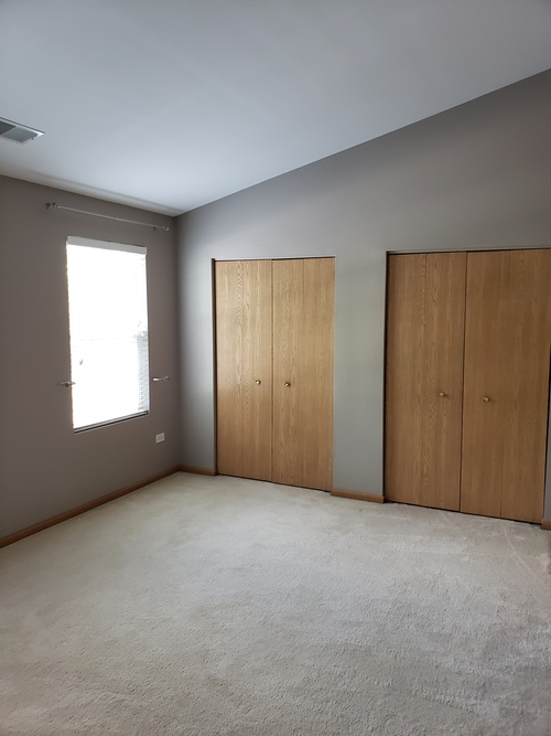 A room with two wooden doors and a window.