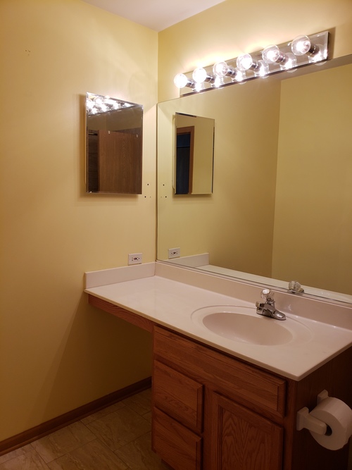 A bathroom with a sink and mirror.