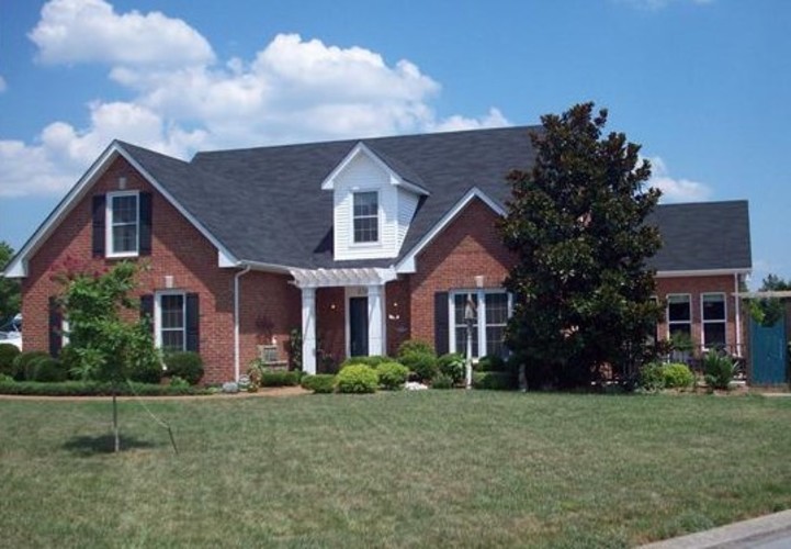 A red brick house with a white door and windows.