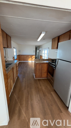 A kitchen with wooden floors and white appliances.