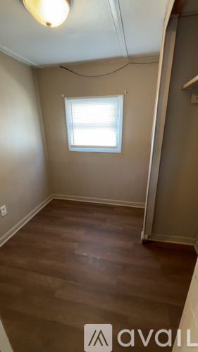 A room with a window and wooden flooring.