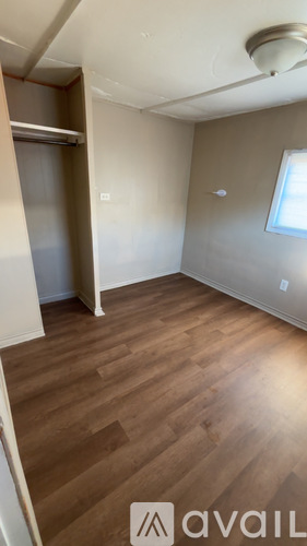 A room with wooden flooring and a window.