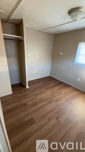 A room with wooden flooring and a window.
